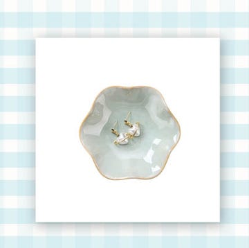 wooden comb and light blue scalloped jewelry dish on a blue and white gingham background