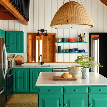 kitchen with green cabinetry and white countertops and a basket light above the island