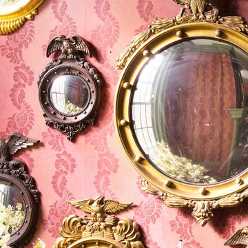 Decorative wall featuring ornate mirrors and a floral arrangement.
