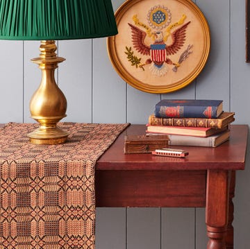 decorative table with books lamp and wall art featuring eagles