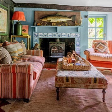 living room with striped sofa and blue fireplace with a large fish above it