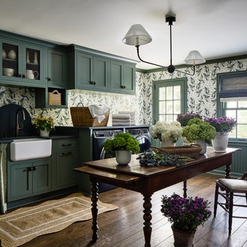 dark green laundry room with large wooden table in the middle
